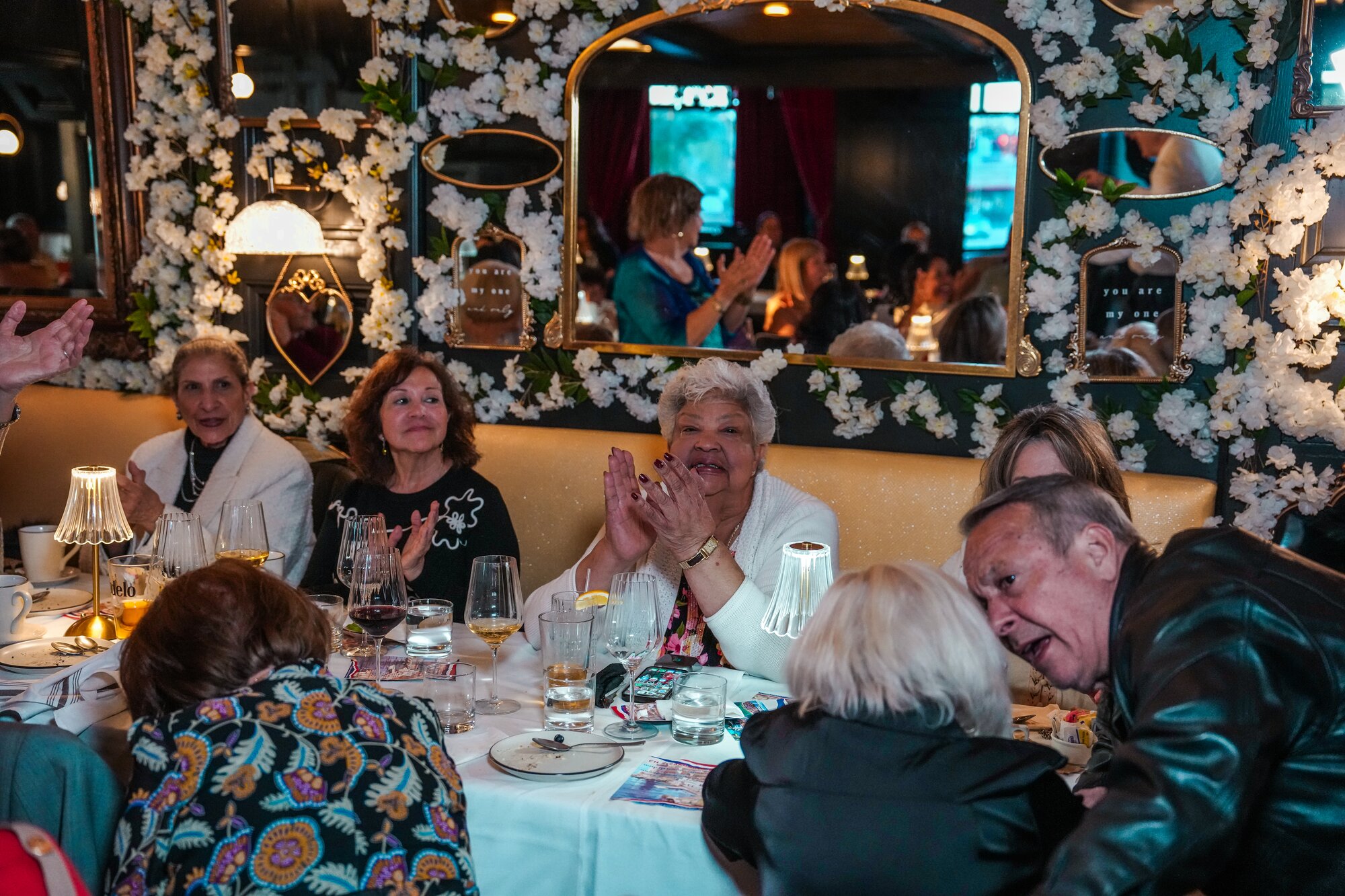 Guests cheering beneath the floral mirror wall