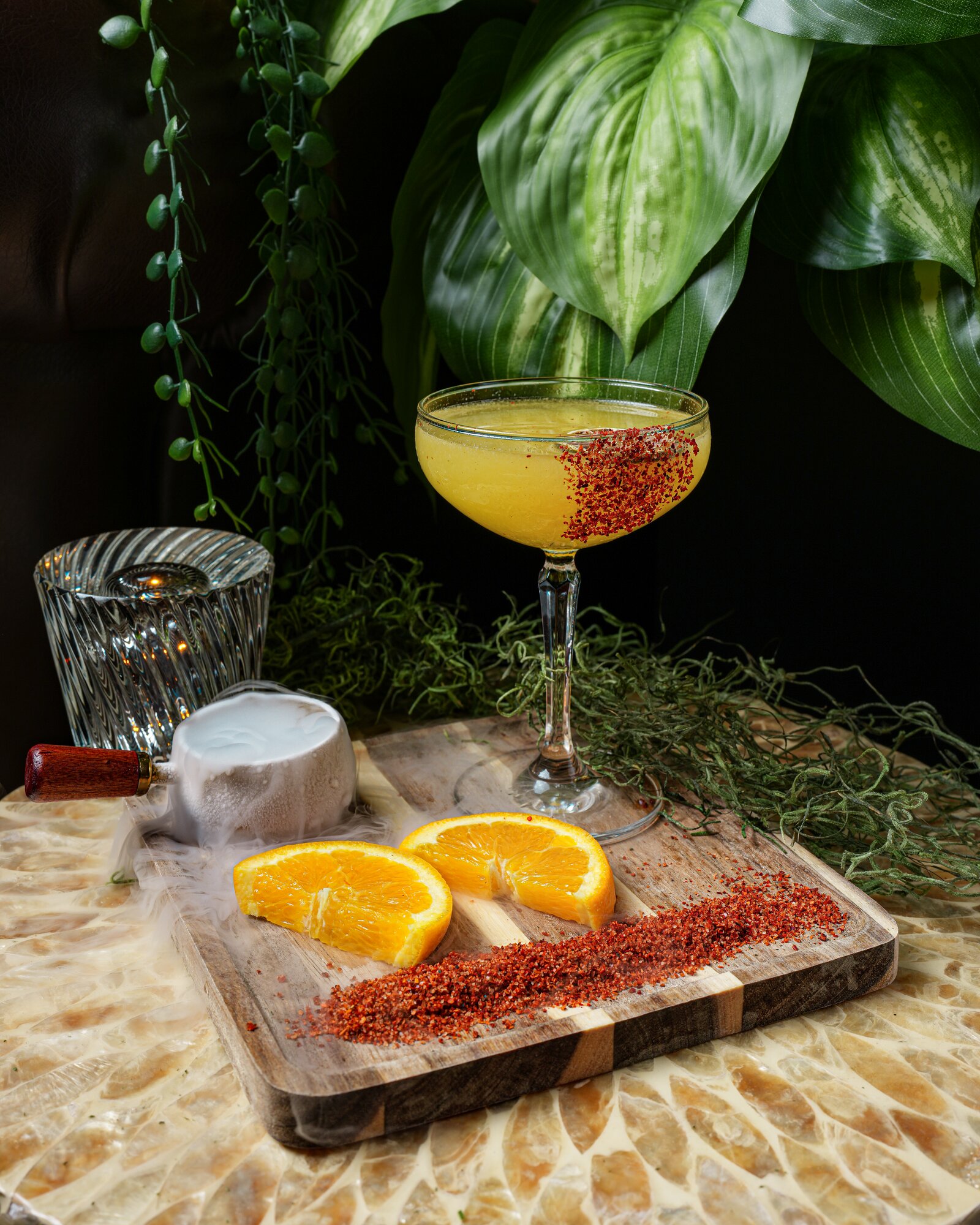 A frozen mango margarita with a chili rim and dry-ice smoke