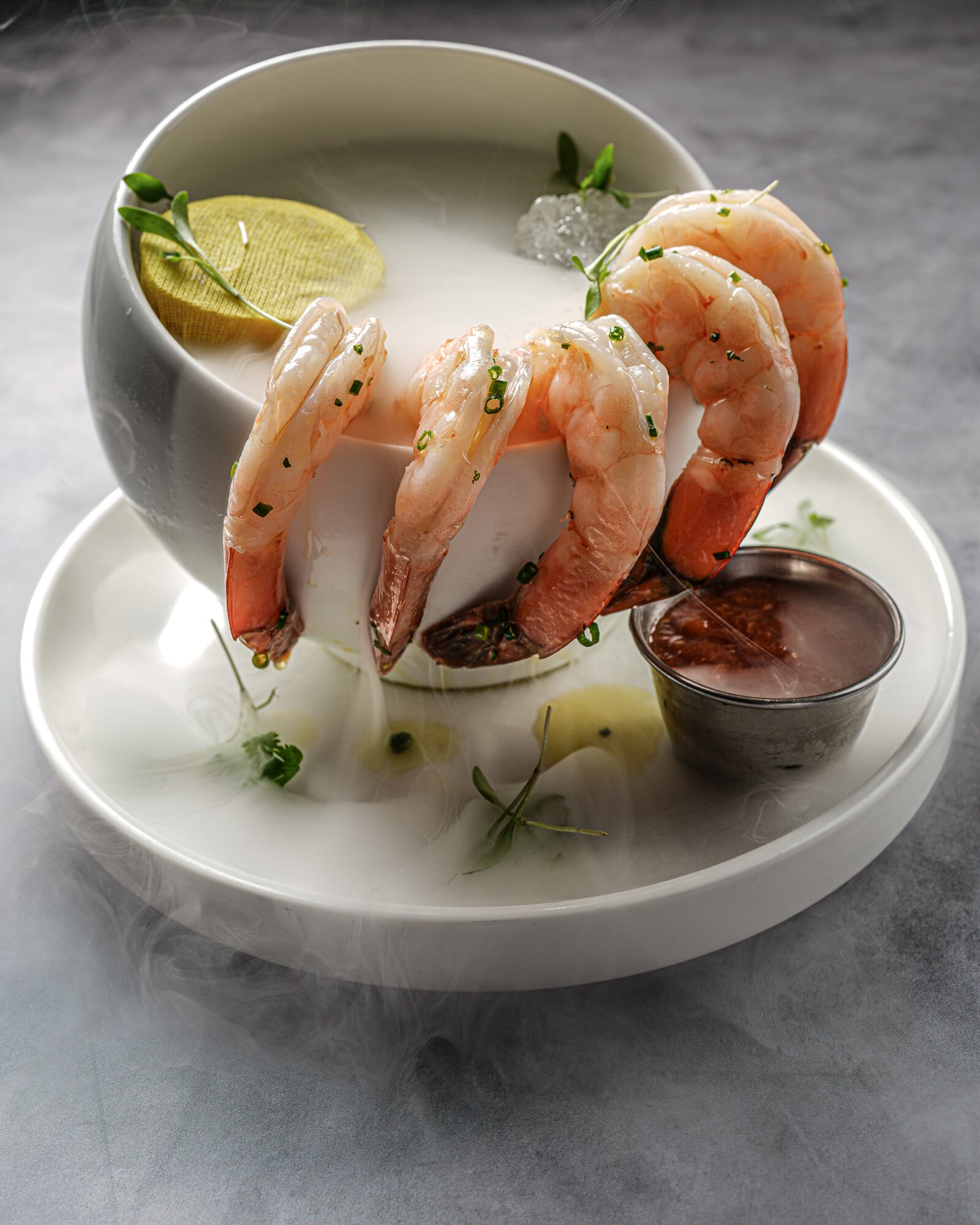 Smoked jumbo shrimp cocktail served over dry-ice fog with cocktail sauce
