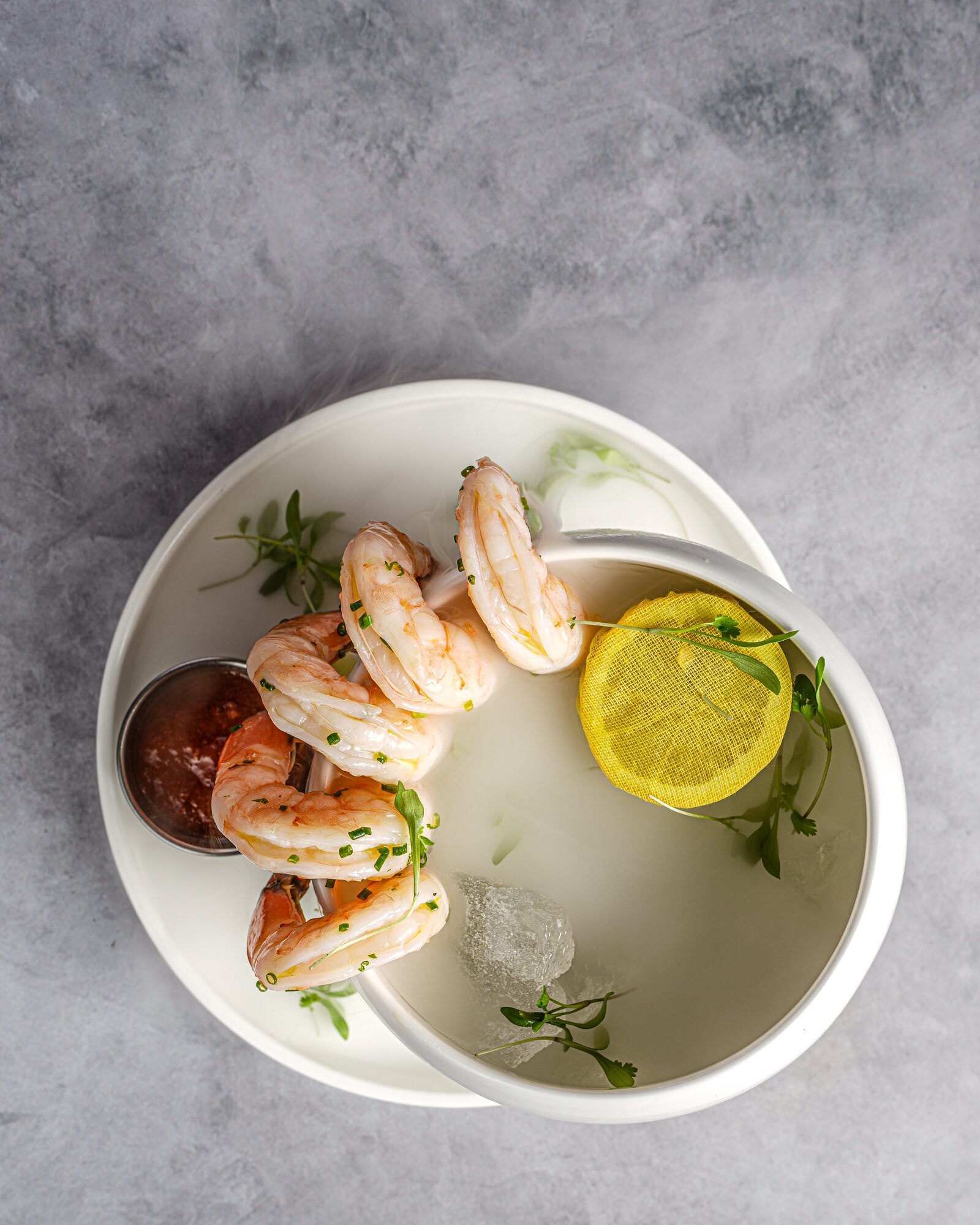 Overhead view of shrimp cocktail with lemon and cocktail sauce