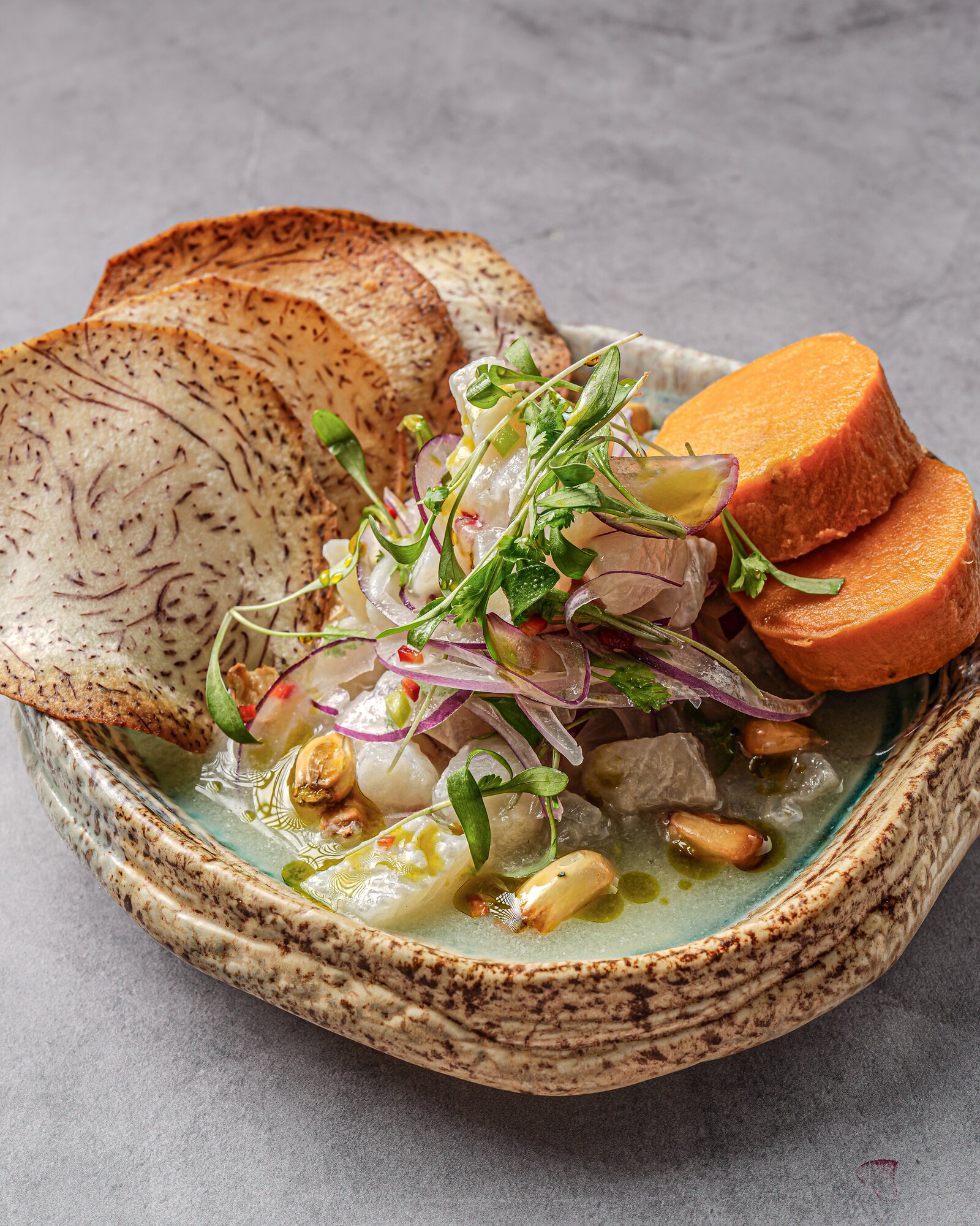 Fresh fish ceviche with red onion, sweet potato and toasted corn