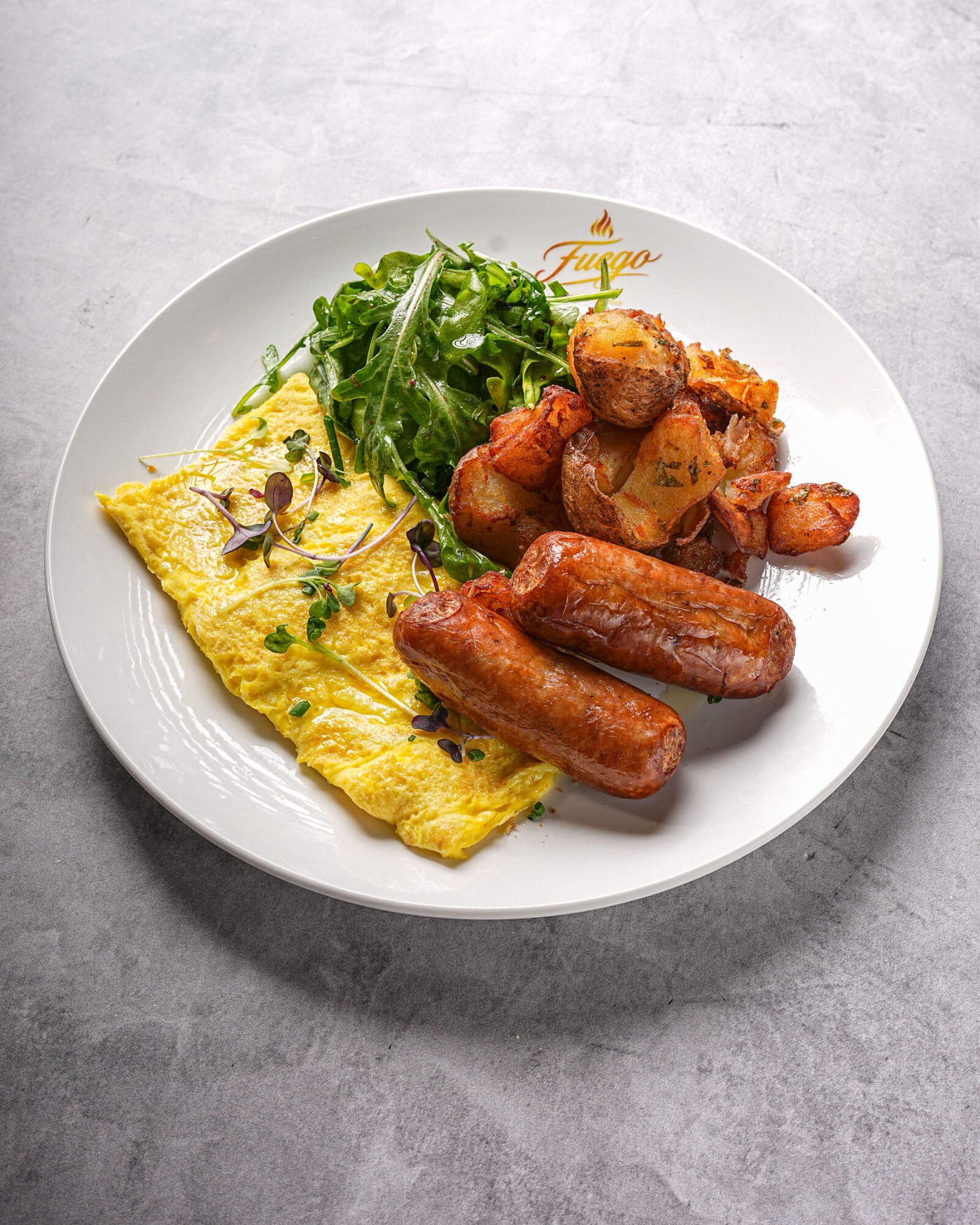 Fluffy omelette with grilled sausage and breakfast potatoes