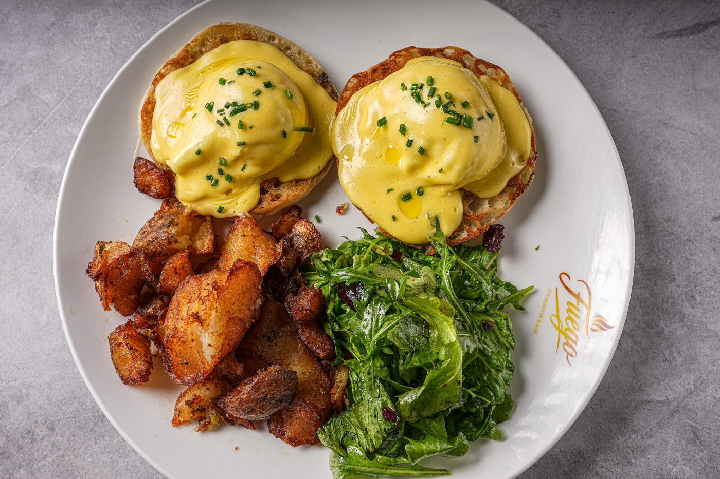 Eggs Benedict served with sautéed kale and potatoes