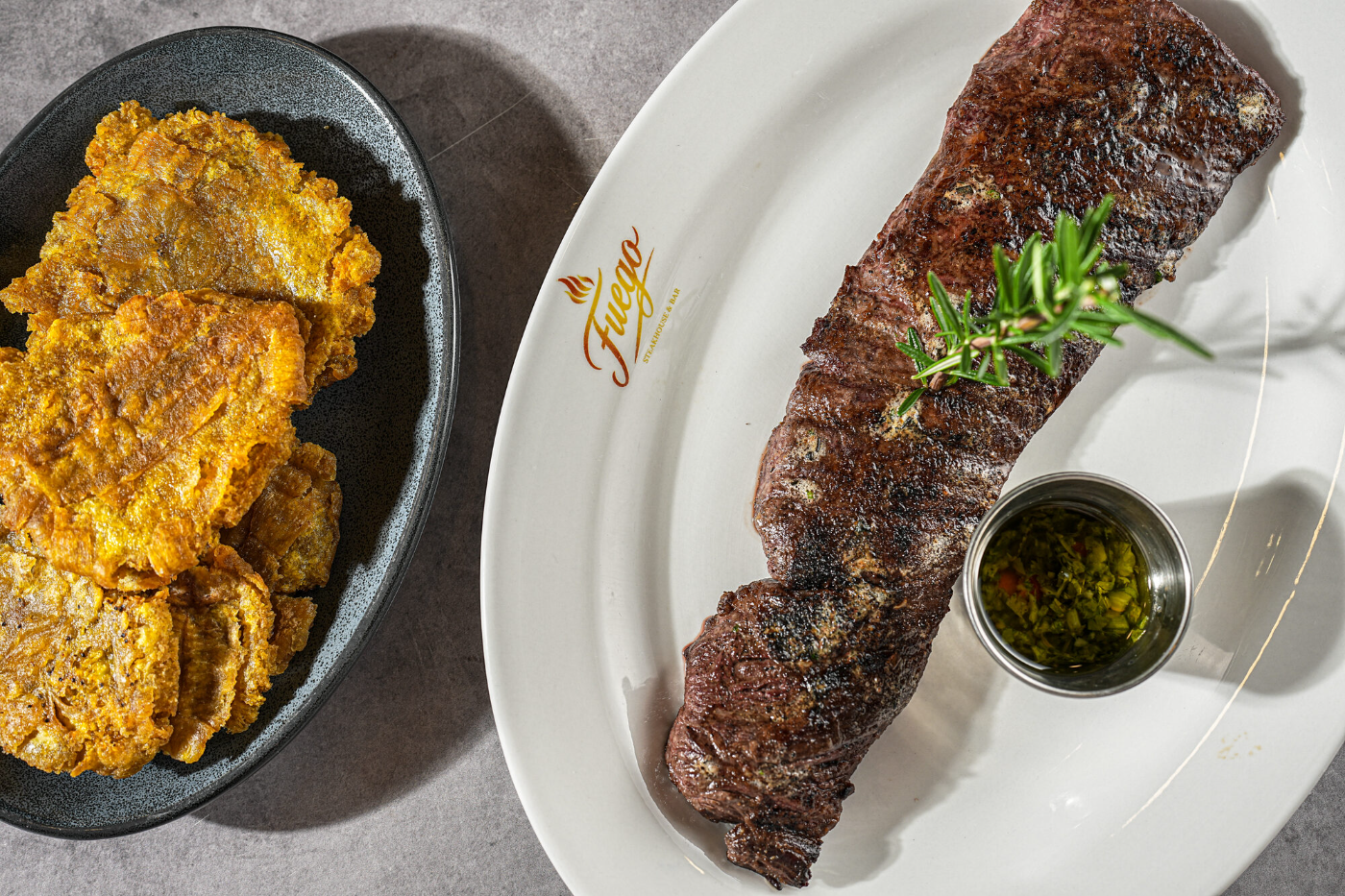 Grilled steak served with crispy tostones and chimichurri