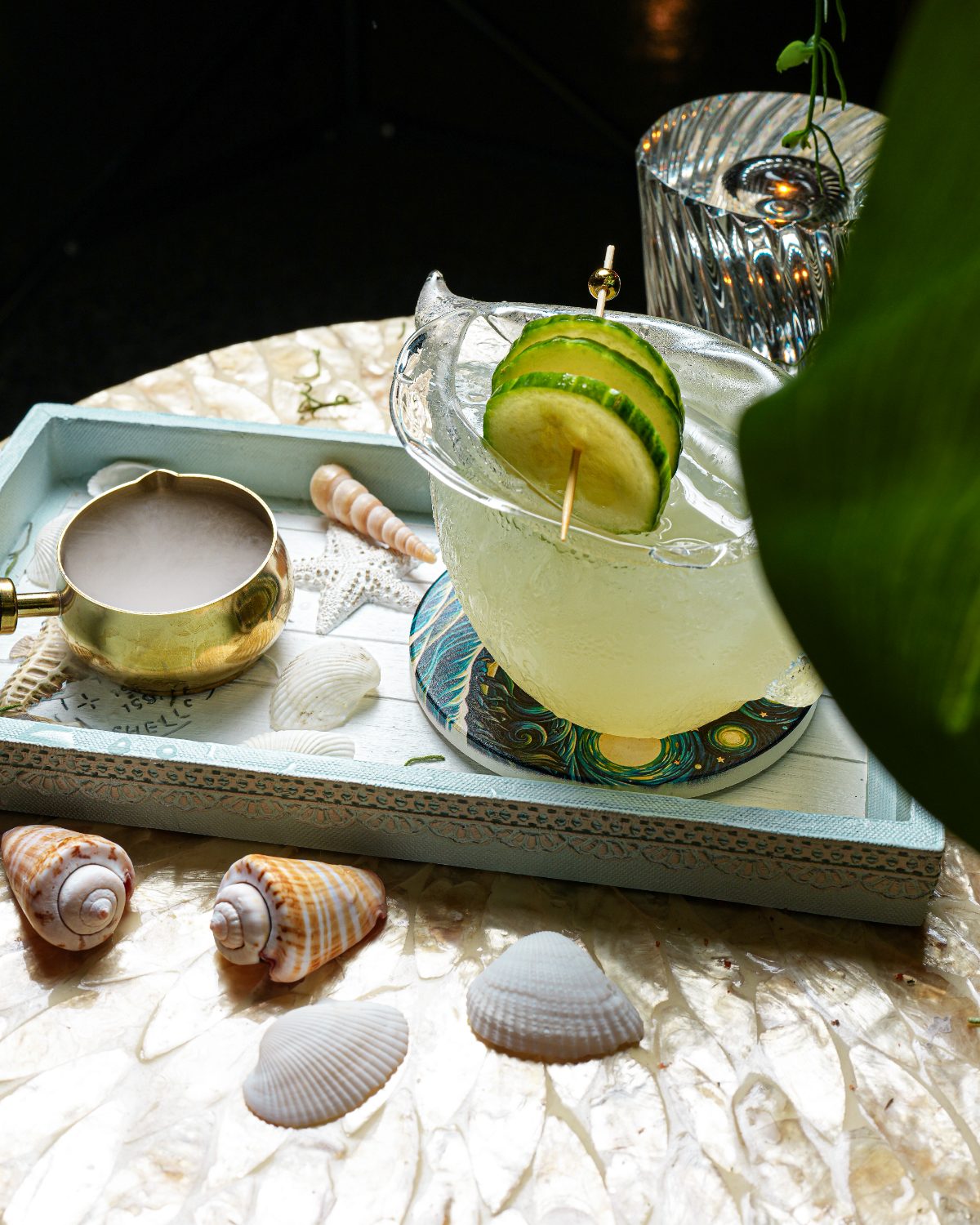 Cucumber highball in a shell glass on a coastal serving tray