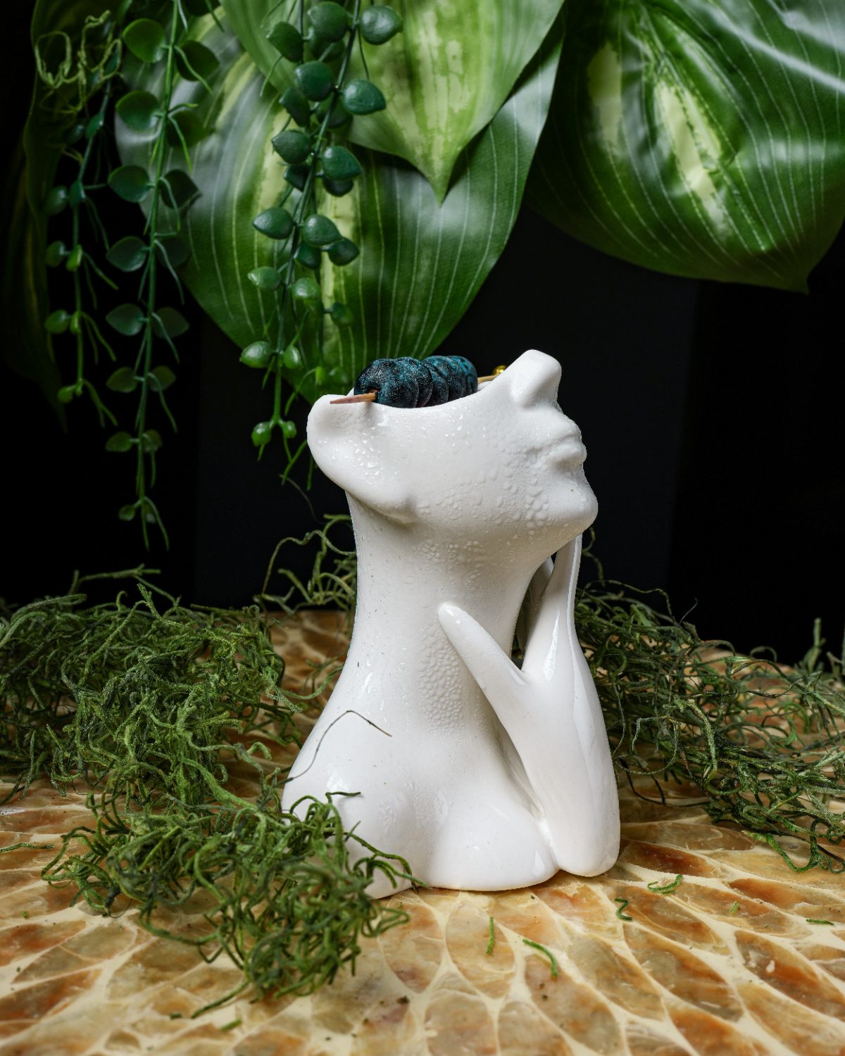 Signature cocktail in a sculpted ceramic tiki mug